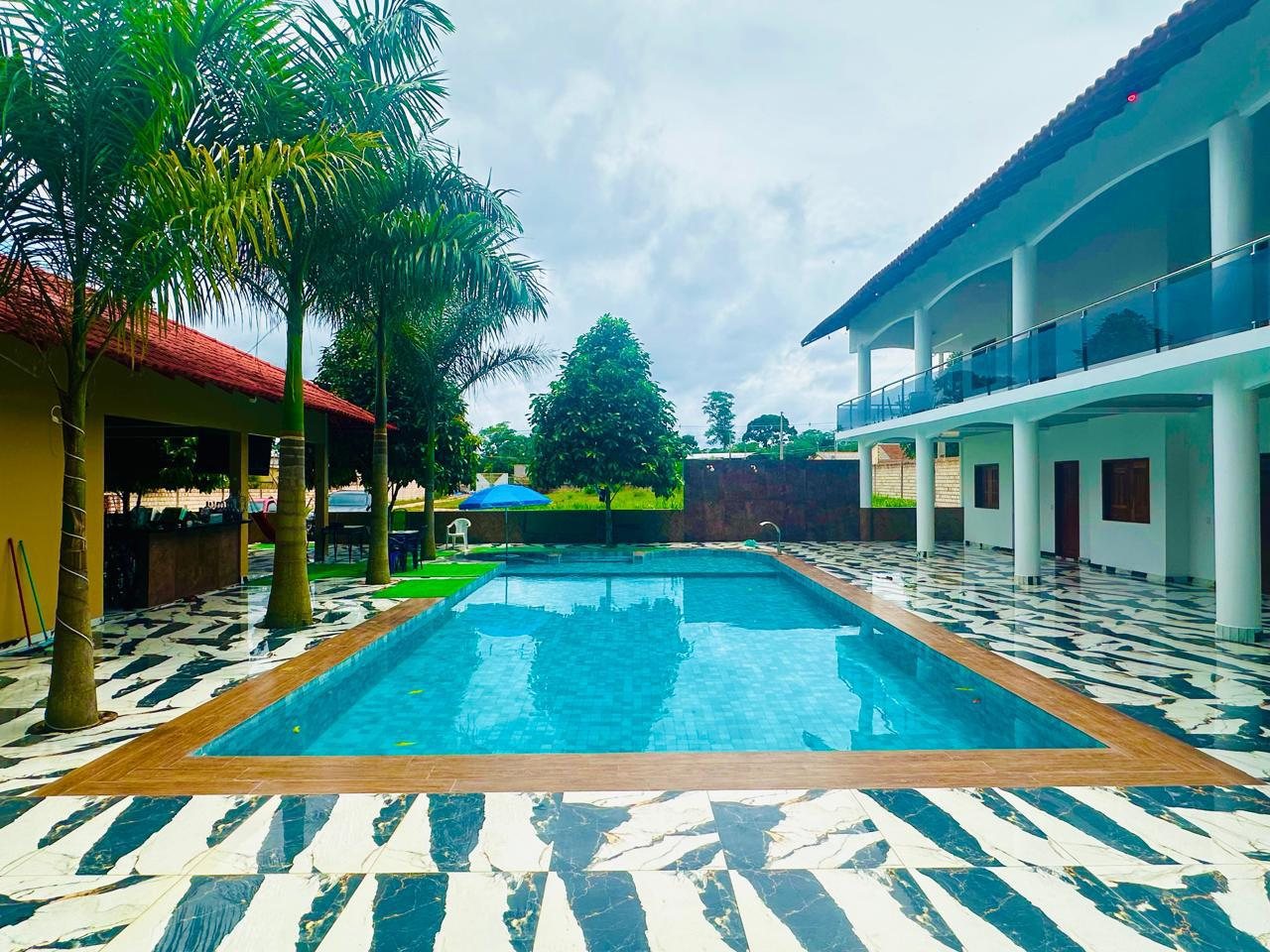Vista geral da Pousada Chalé Caribe com piscina, suítes e terreno, disponível para aluguel completo
